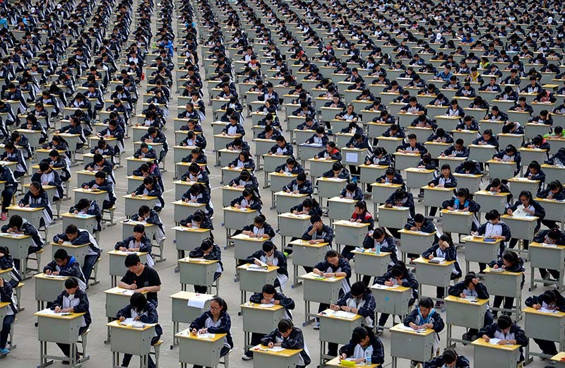 Image: Students take an examination on an open-air playground at a high school in Yichuan